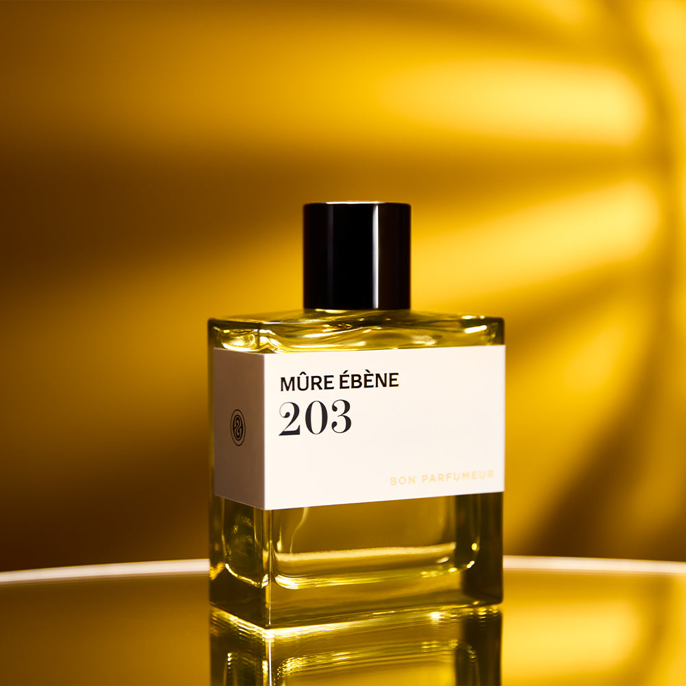 Bon Parfumeur 203 Mûre Ébène Parfumflakon vor goldenem Hintergrund mit Licht und Schatten