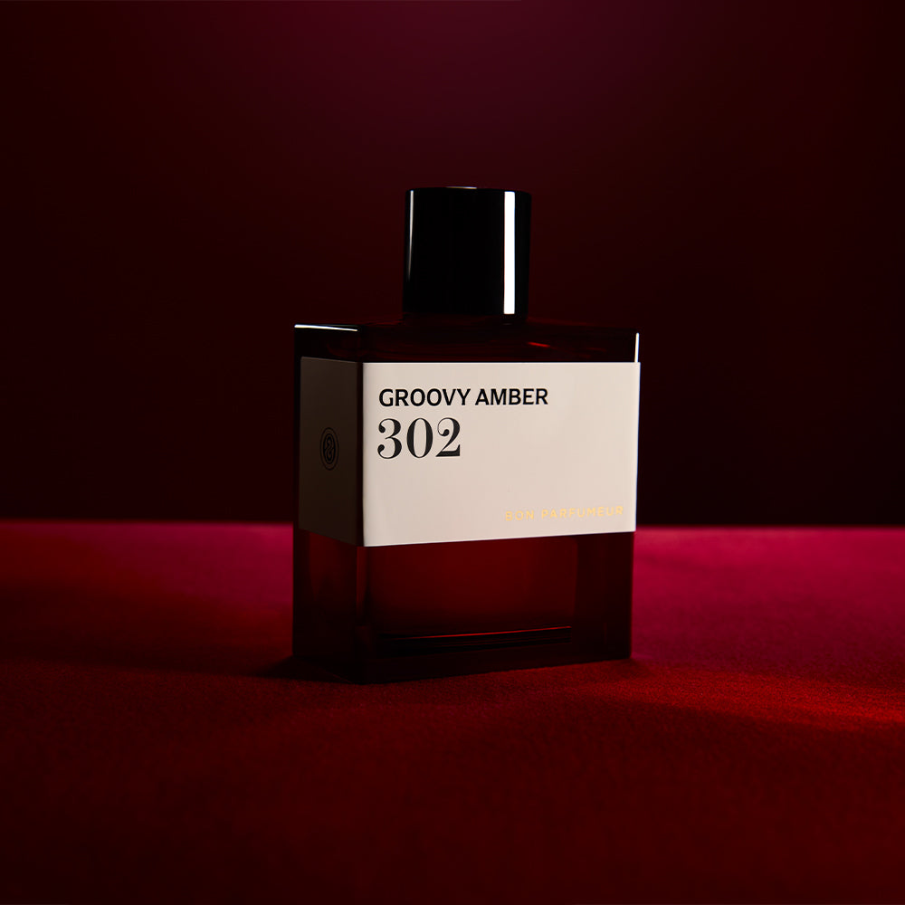 Bon Parfumeur 302 Groovy Amber Parfumflakon vor dunkelrotem Hintergrund